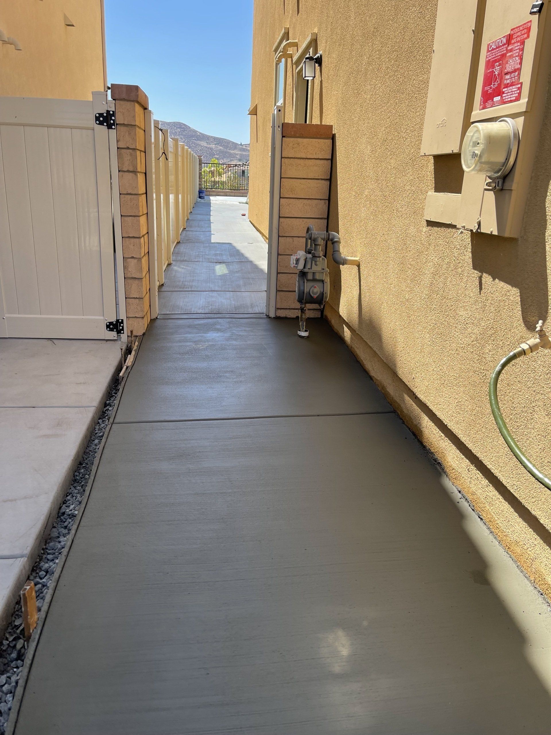 newly cemented house walkway with white gate