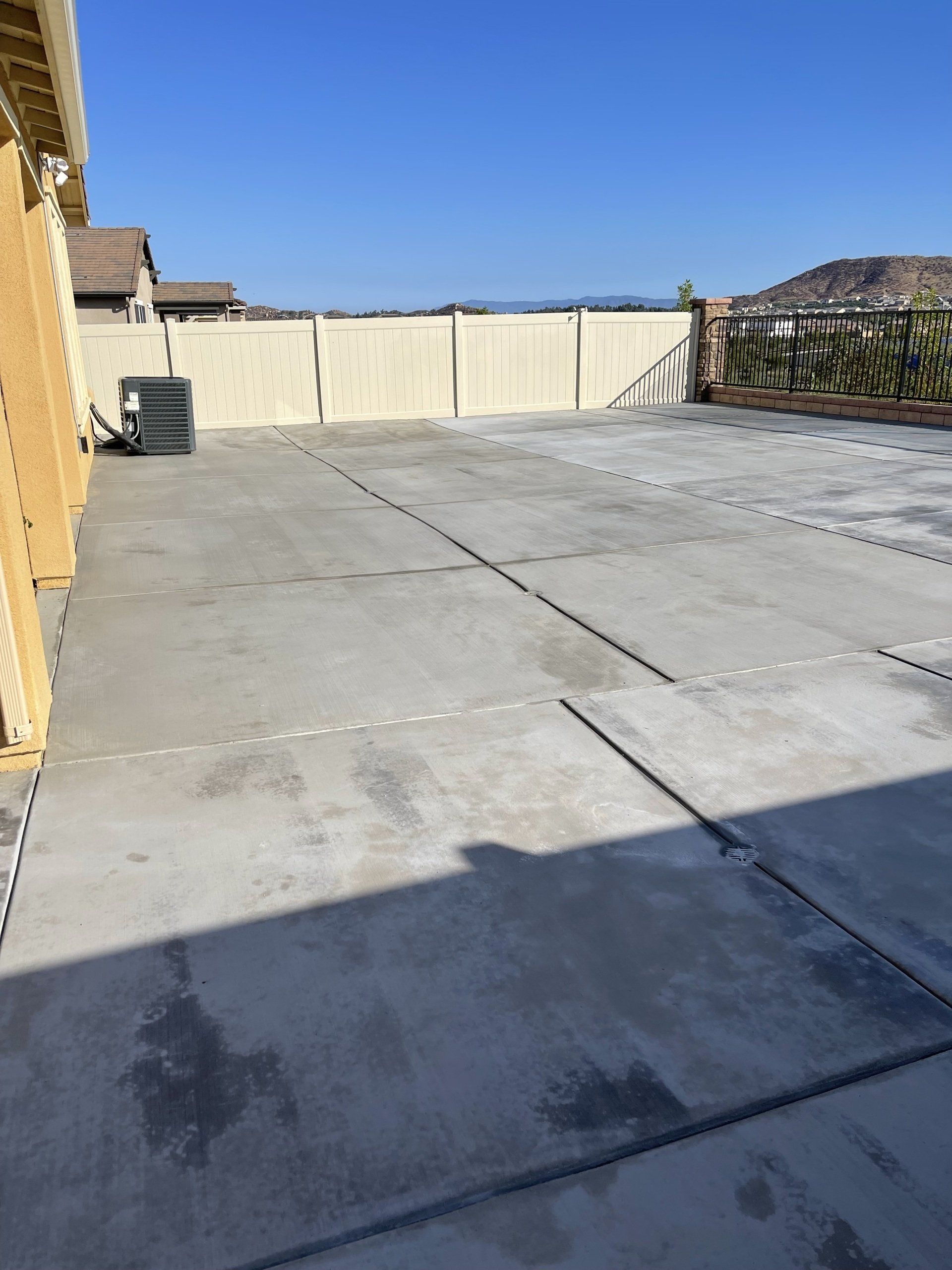 semi finished cemented open spaced backyard with white fence