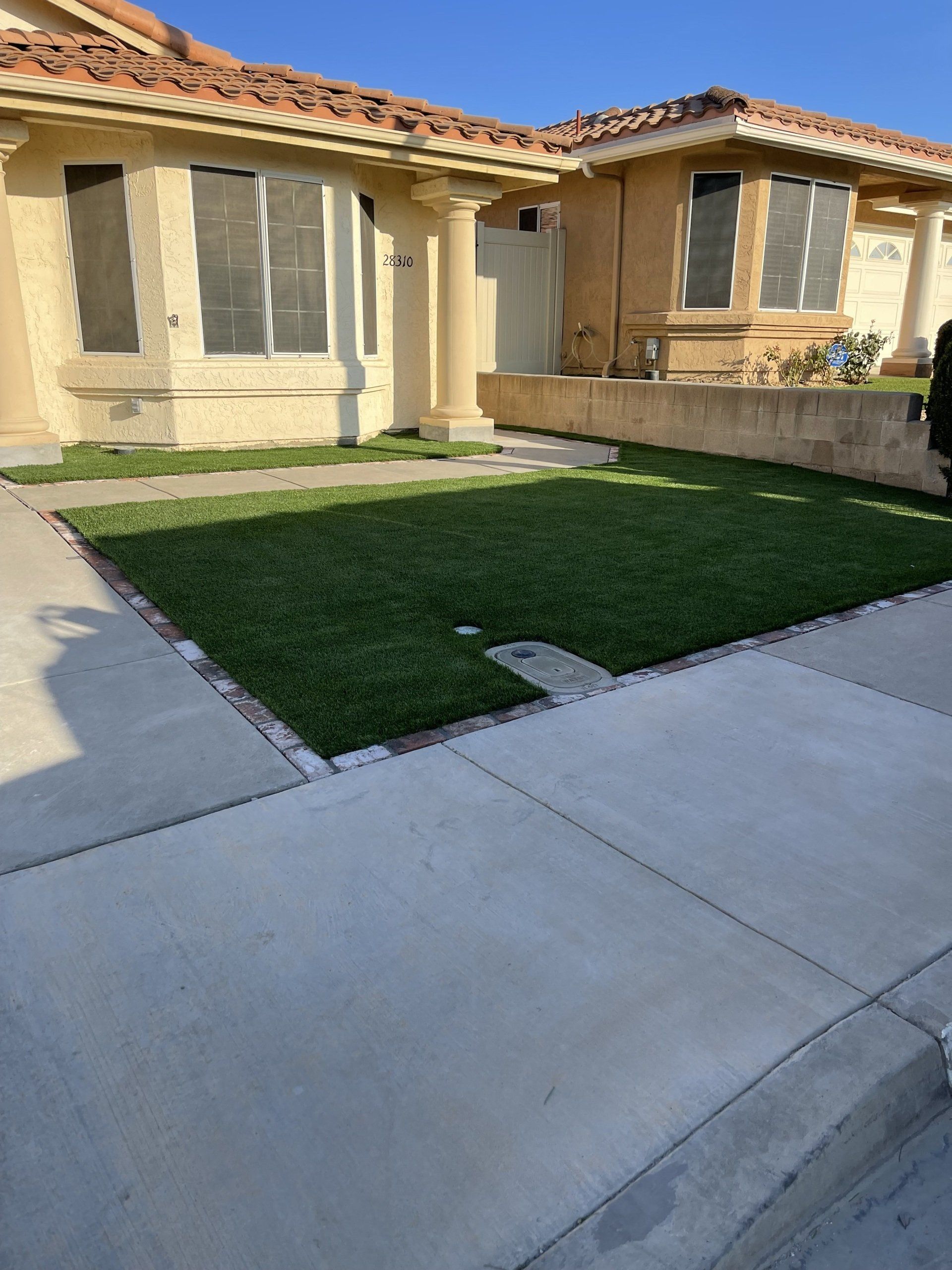 light cream house with light brown roof and lawn