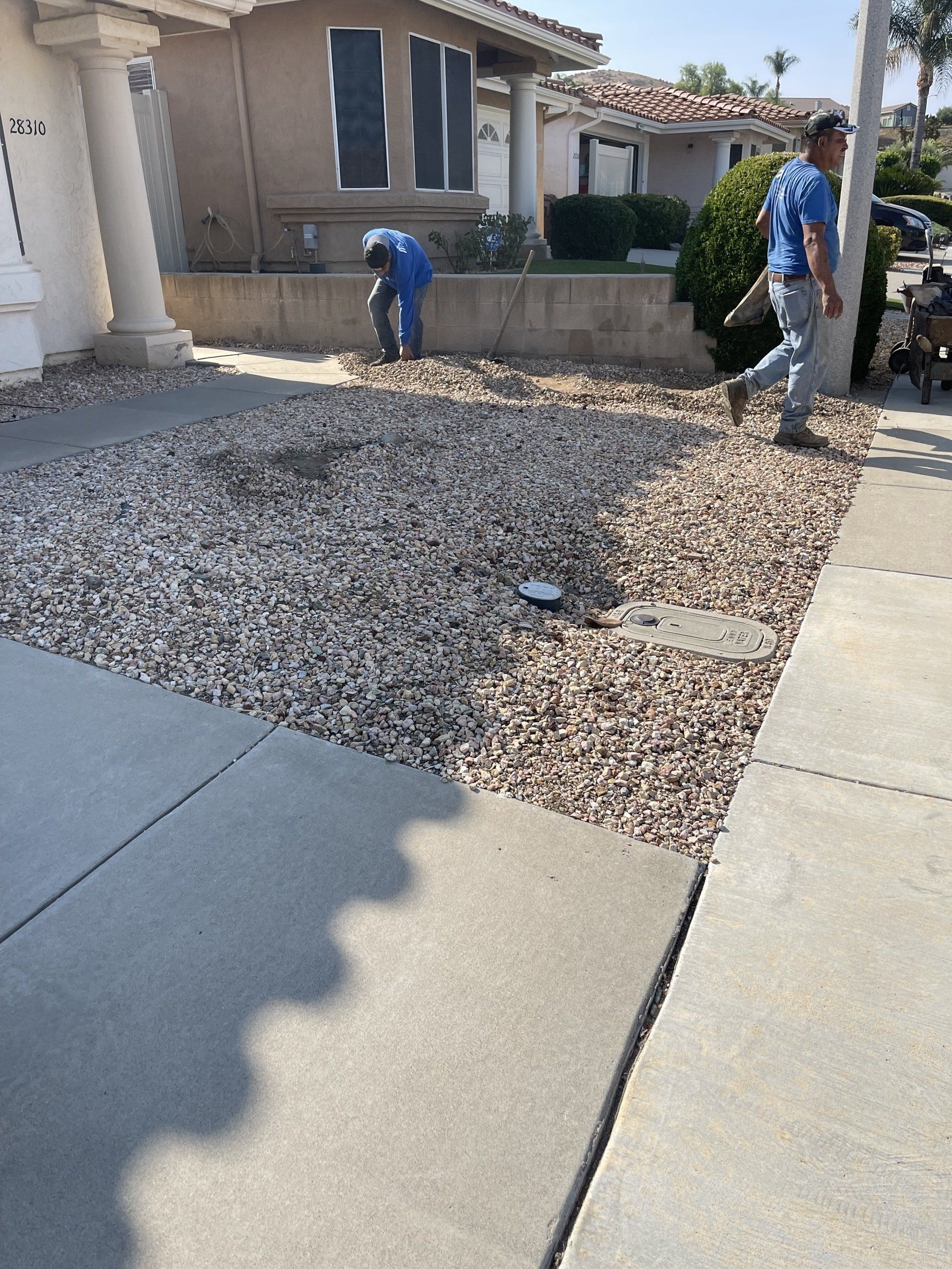 men working on front yard landscaping