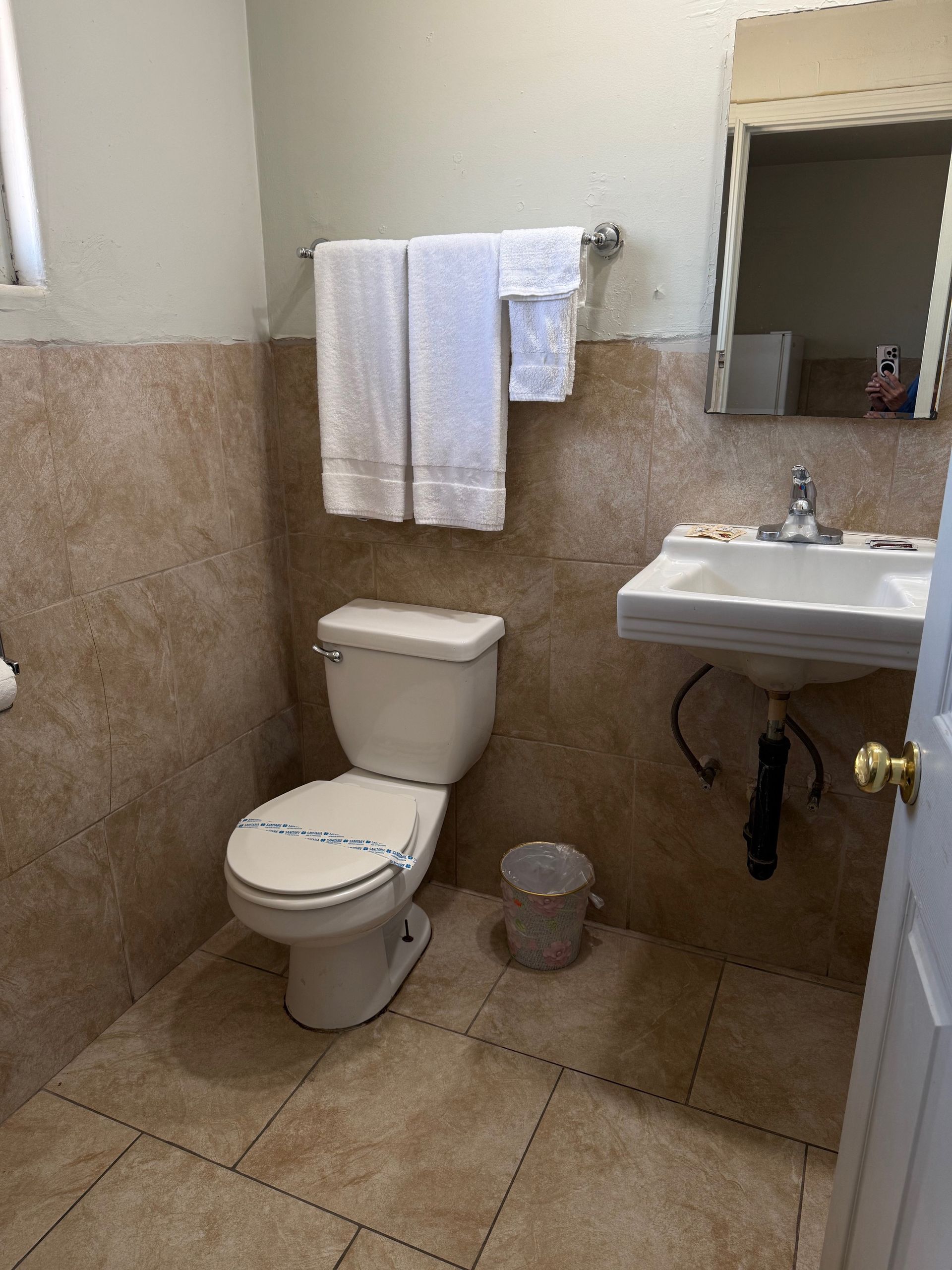 A bathroom with a toilet , sink and mirror