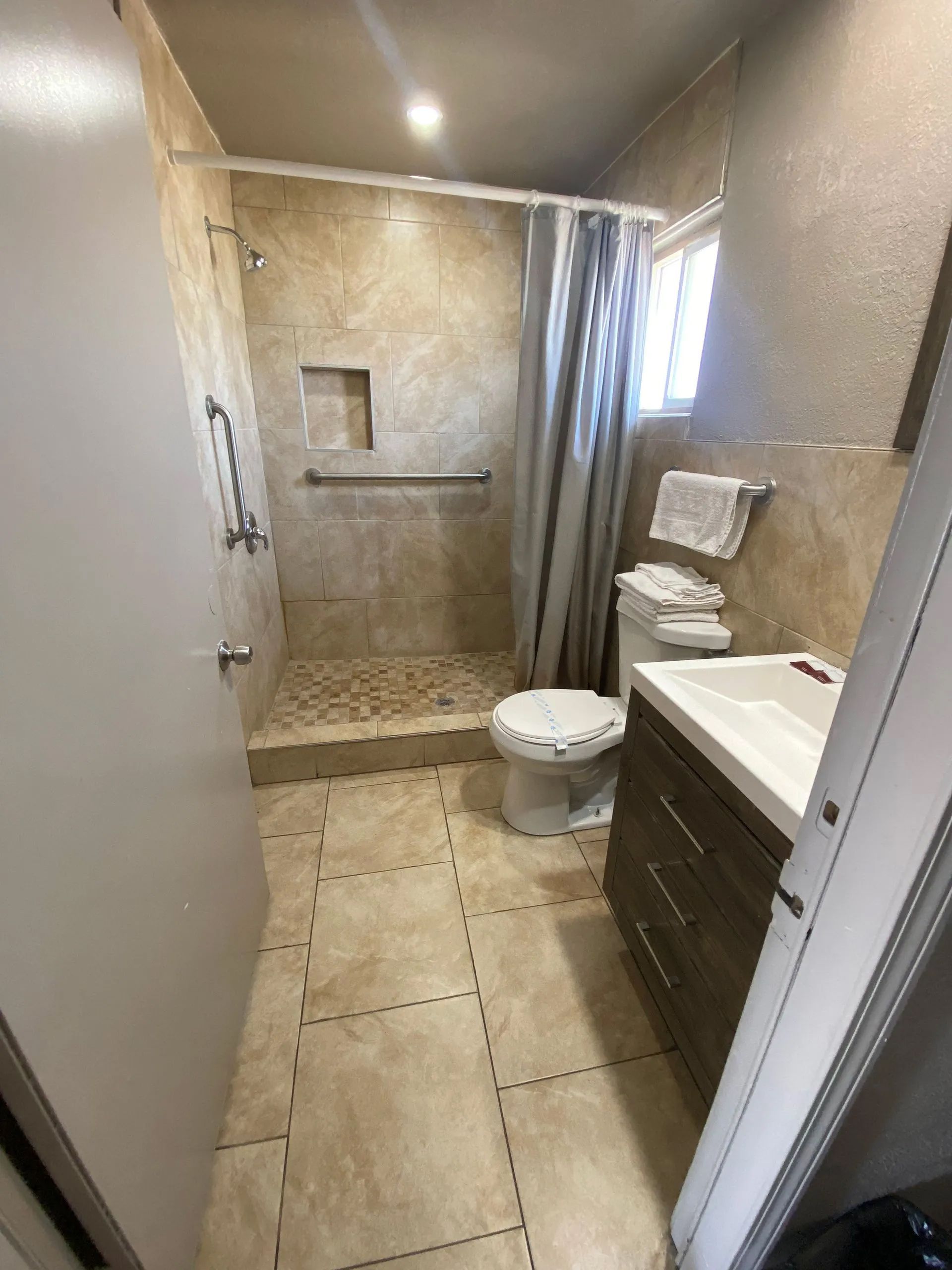 A bathroom with a toilet, sink and shower.