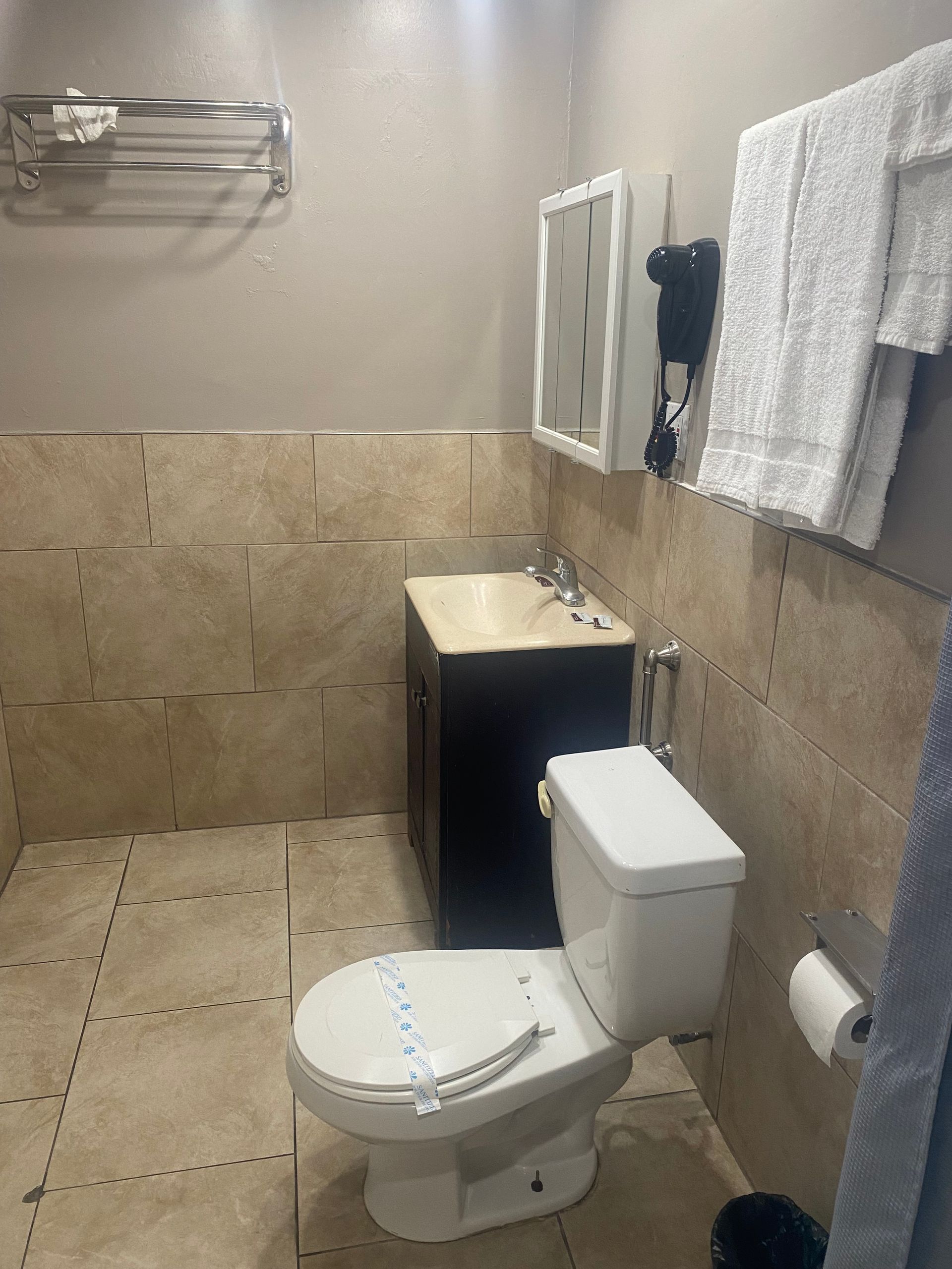 A bathroom with a toilet , sink and mirror