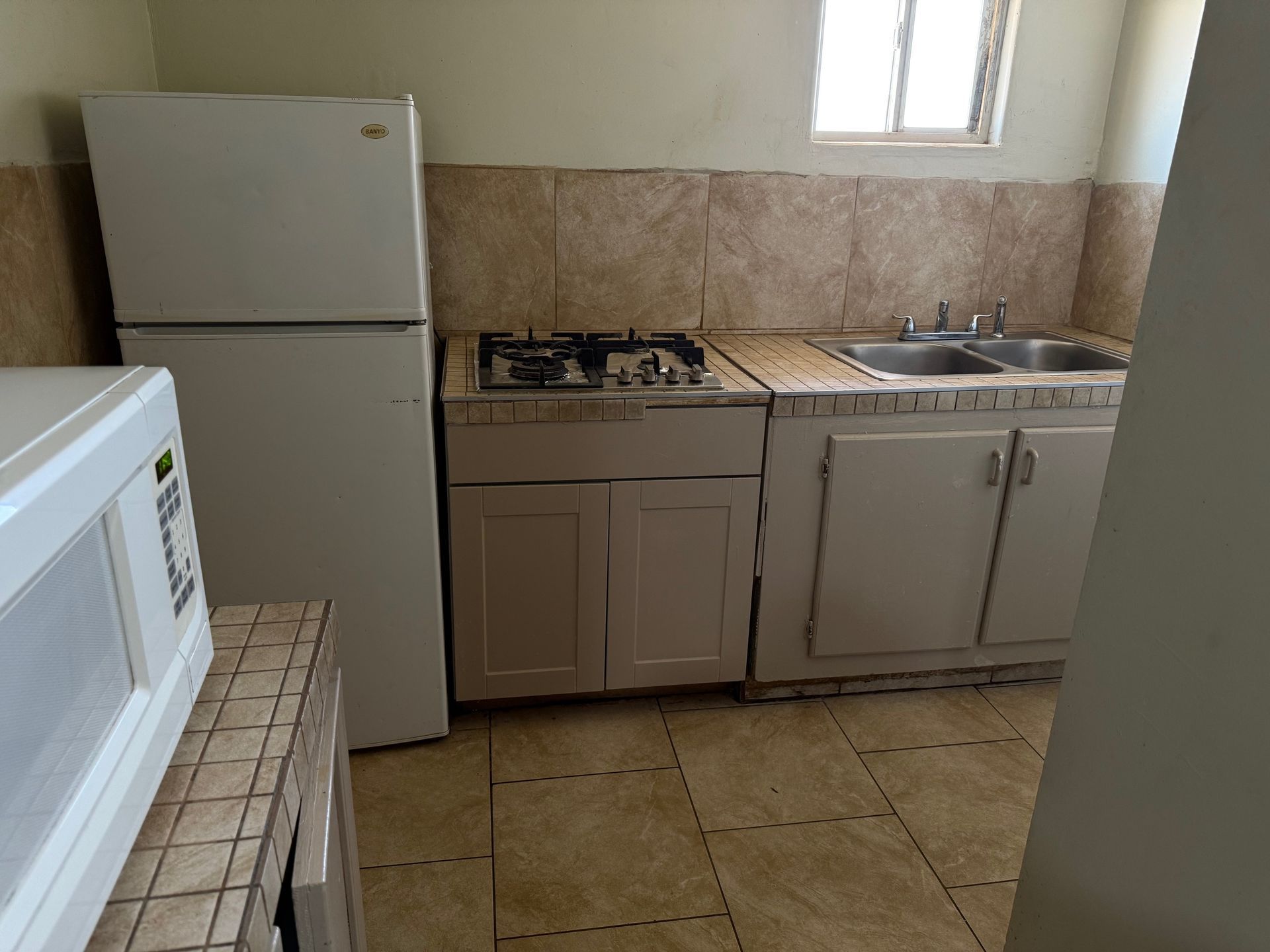 A kitchen with a refrigerator stove sink and microwave