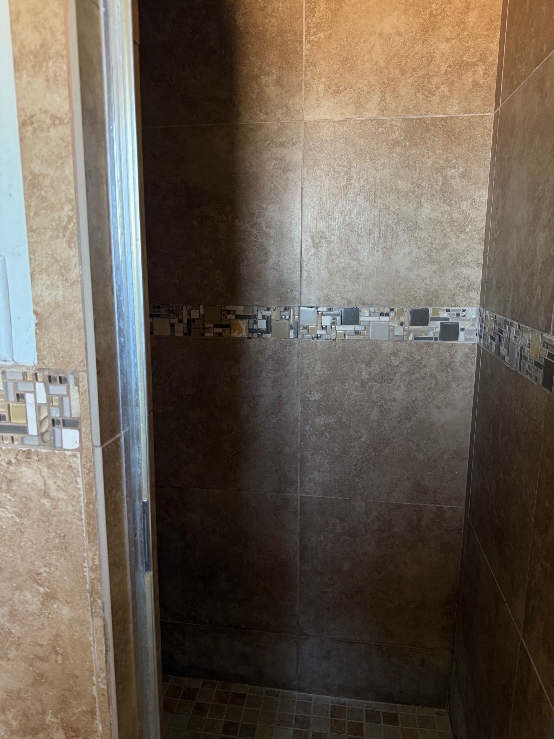 A bathroom with tiled walls and a sliding glass door