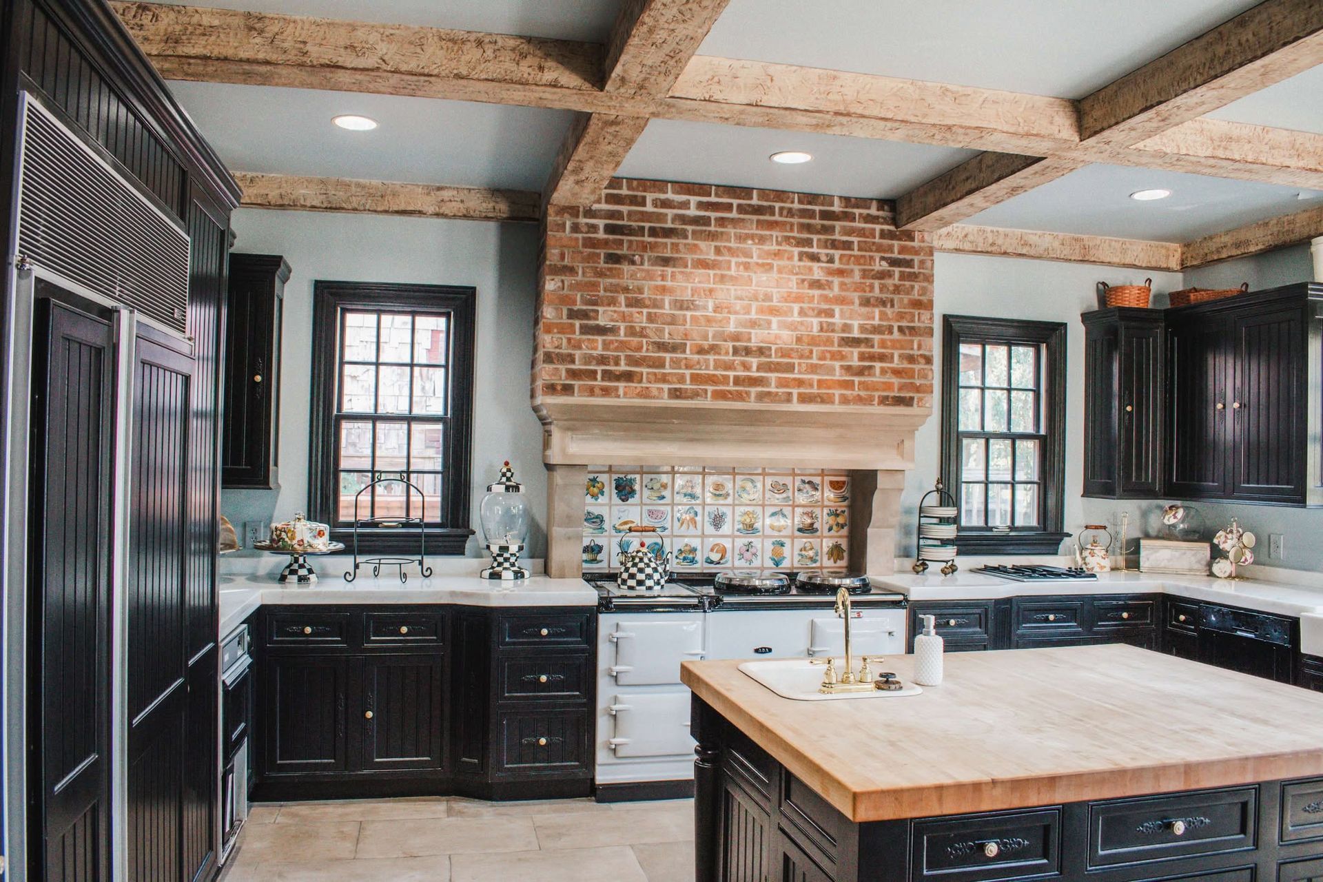 A kitchen with black cabinets and a wooden counter top