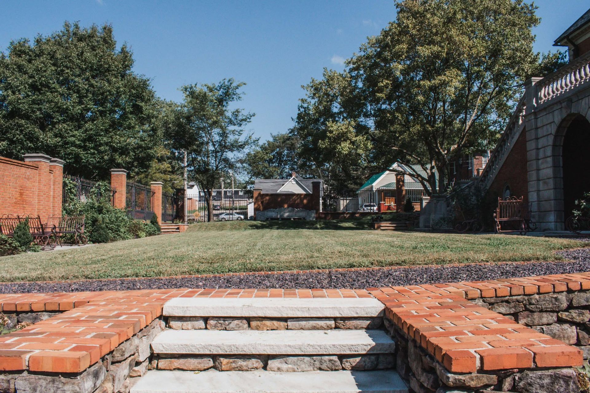 There are brick steps leading up to a grassy field.