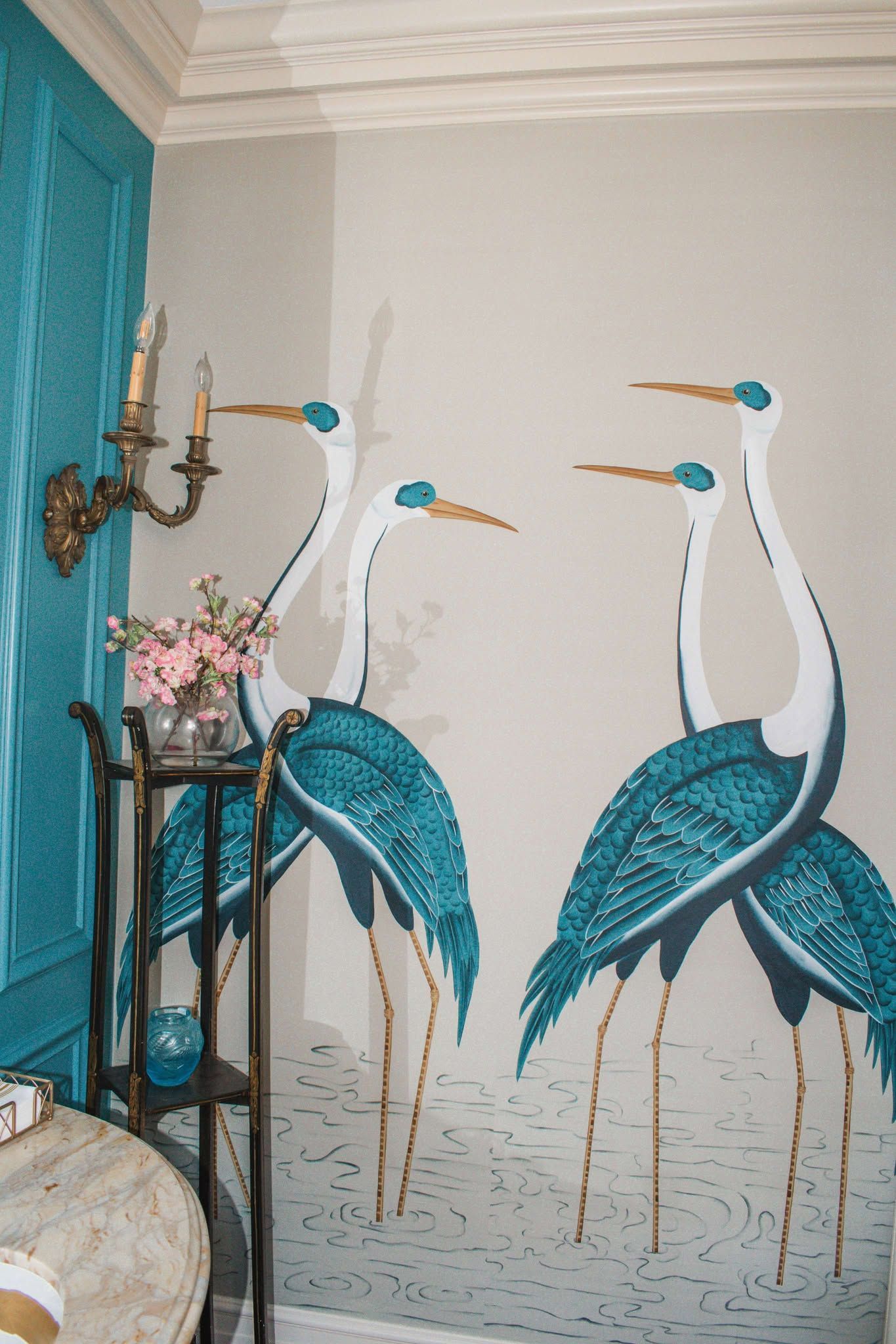 Three birds are painted on a wall in a room