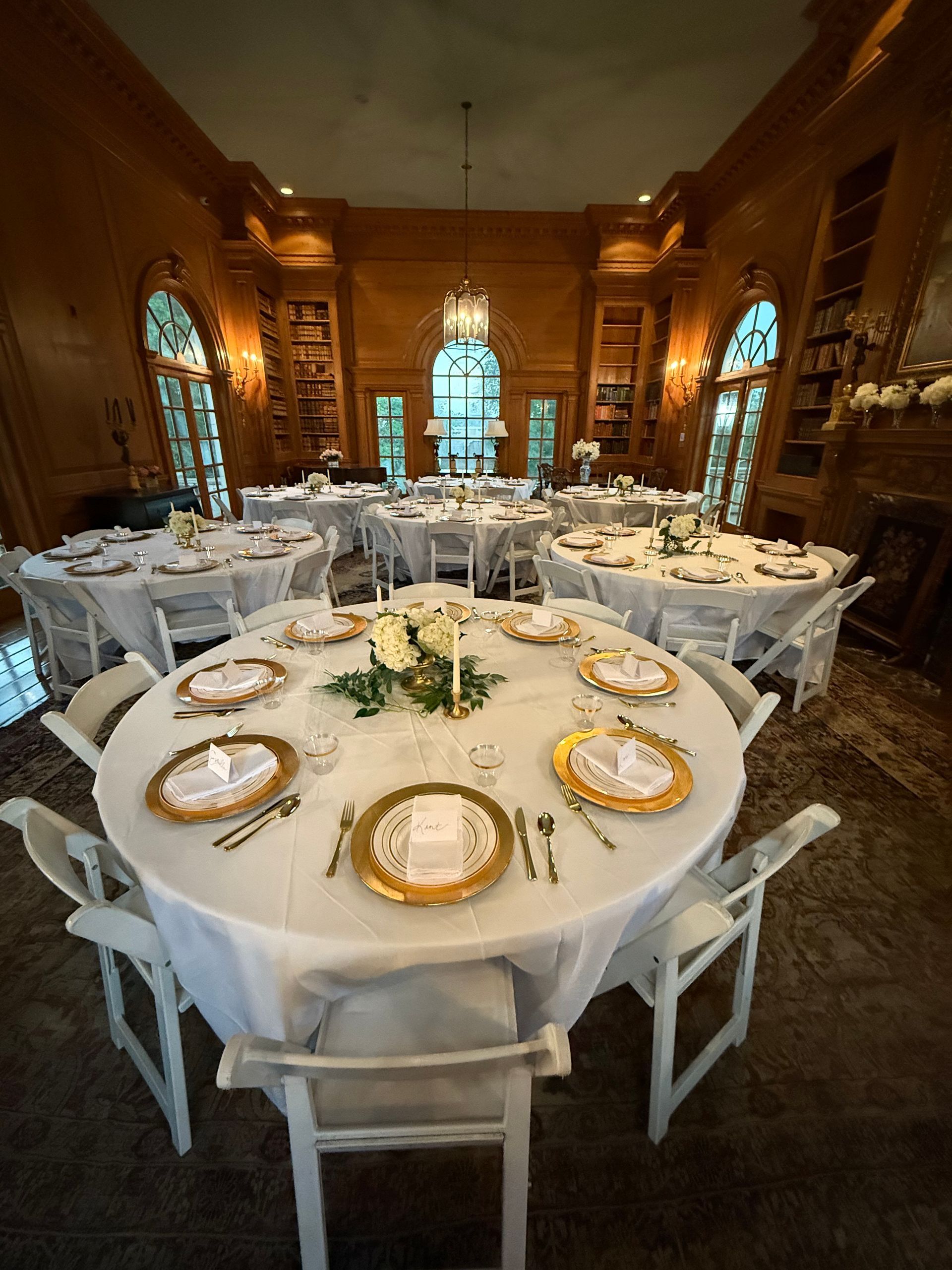 A large room with tables and chairs set up for a wedding reception.