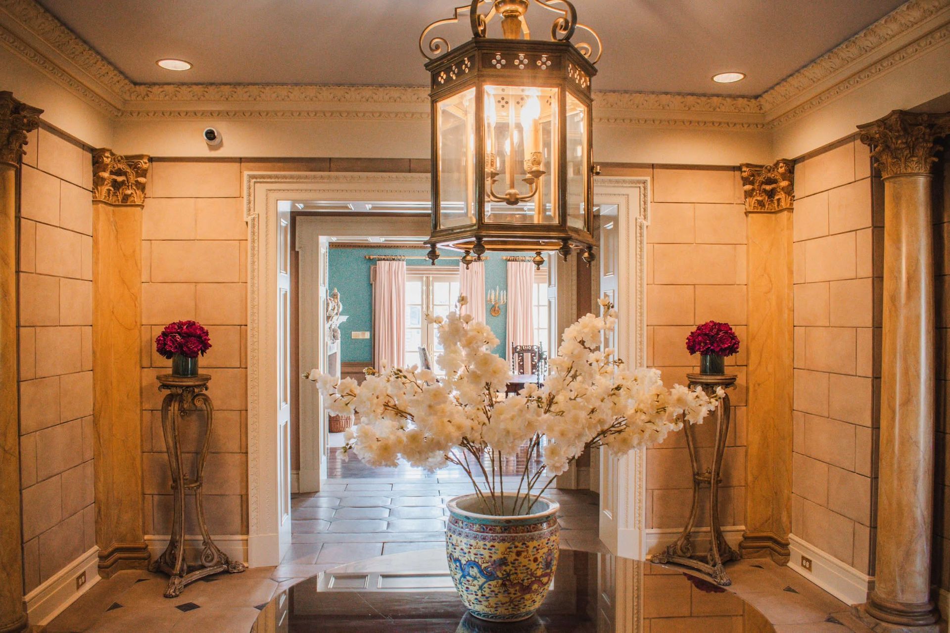 There is a vase of flowers in the middle of the hallway.