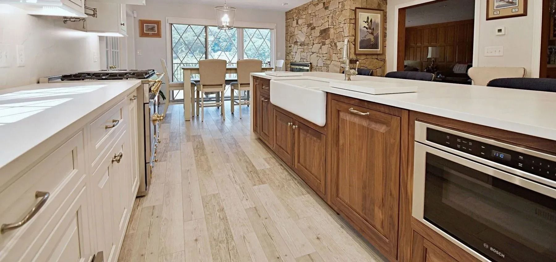Kitchen with white countertops, wooden cabinets, and large island with oven.
