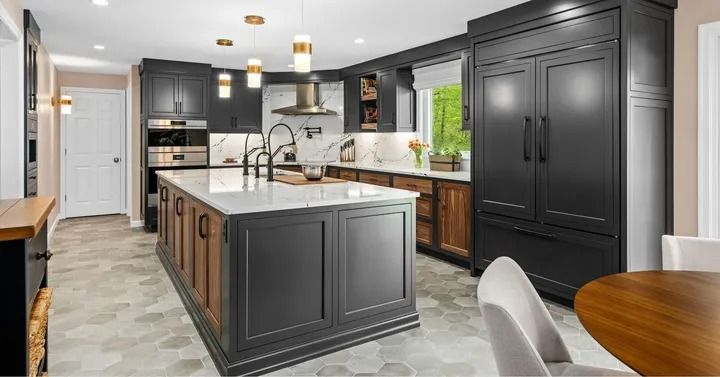 Modern kitchen with dark cabinets, a large island, and stainless steel appliances.