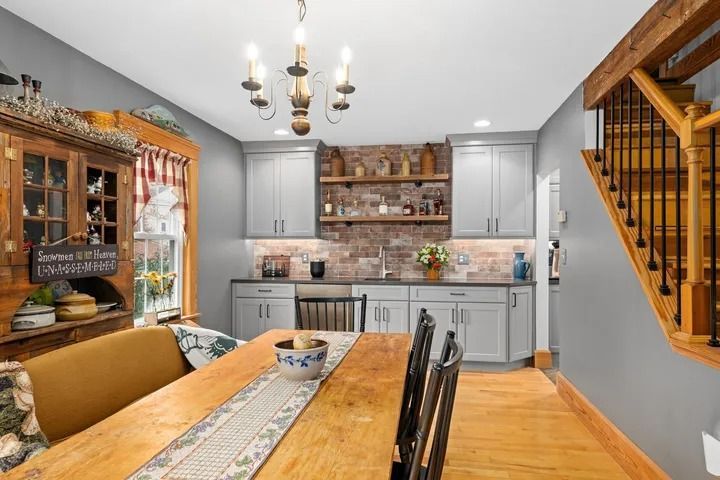 Dining room with a wooden table, built-in cabinetry, and a staircase.