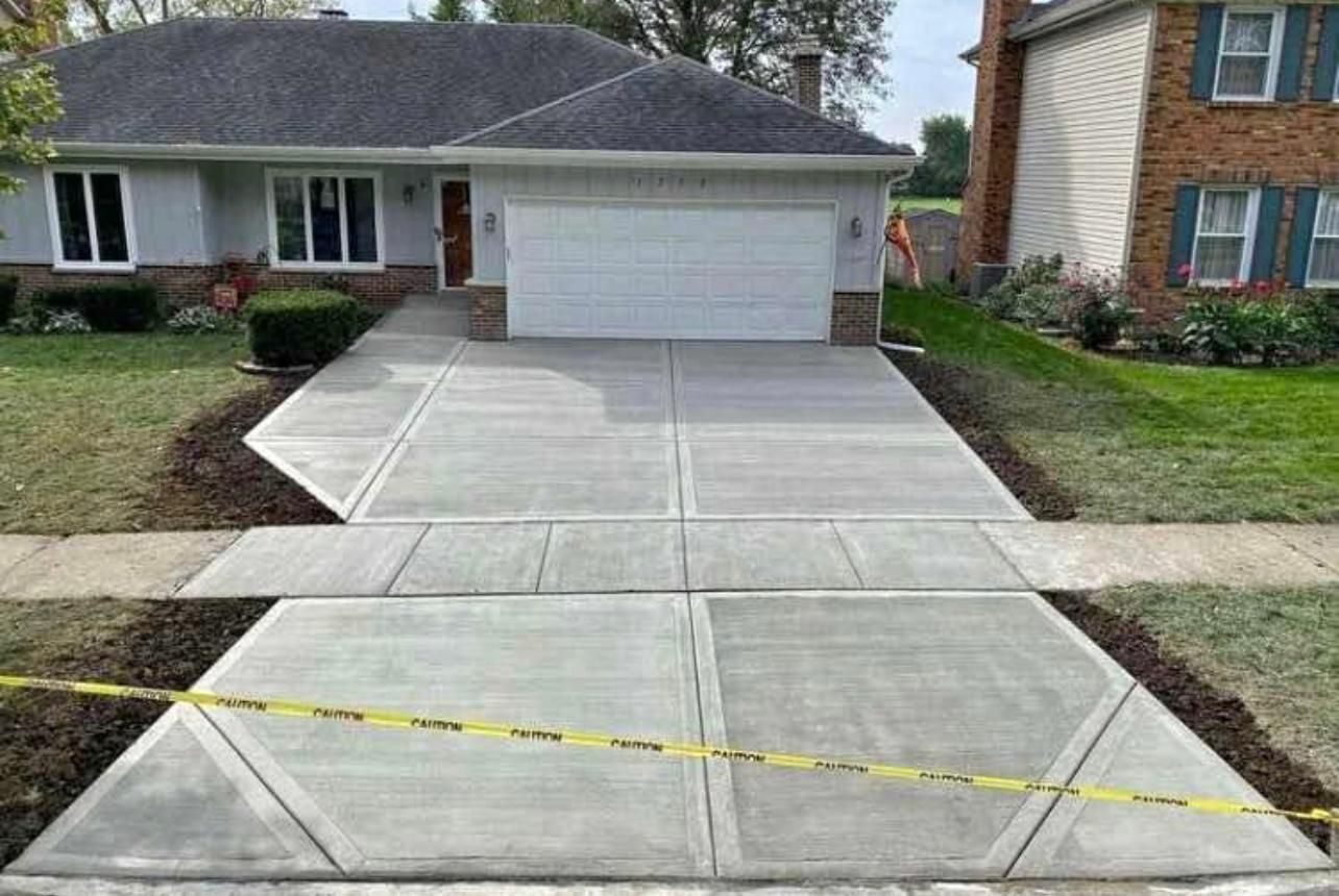 A concrete driveway is being built in front of a house.