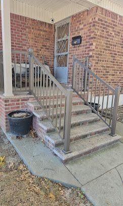 Brick house front steps with metal handrails 