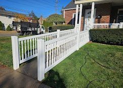 White ramp and fence leading to a brick house