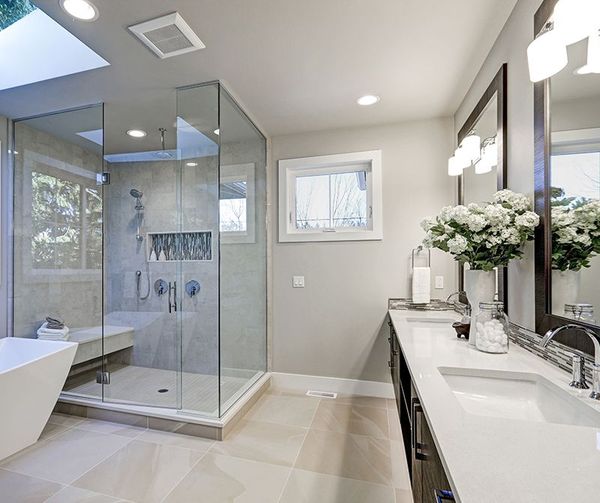 A bathroom with two sinks and a walk in shower