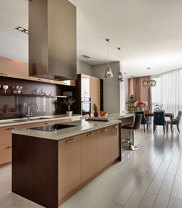 A kitchen with brown cabinets and a large island in the middle