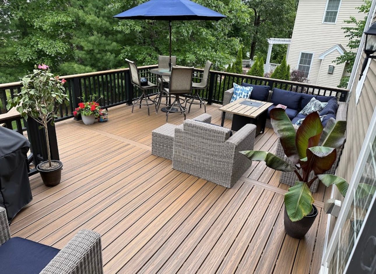Outdoor deck with composite boards, black railing, and patio furniture.
