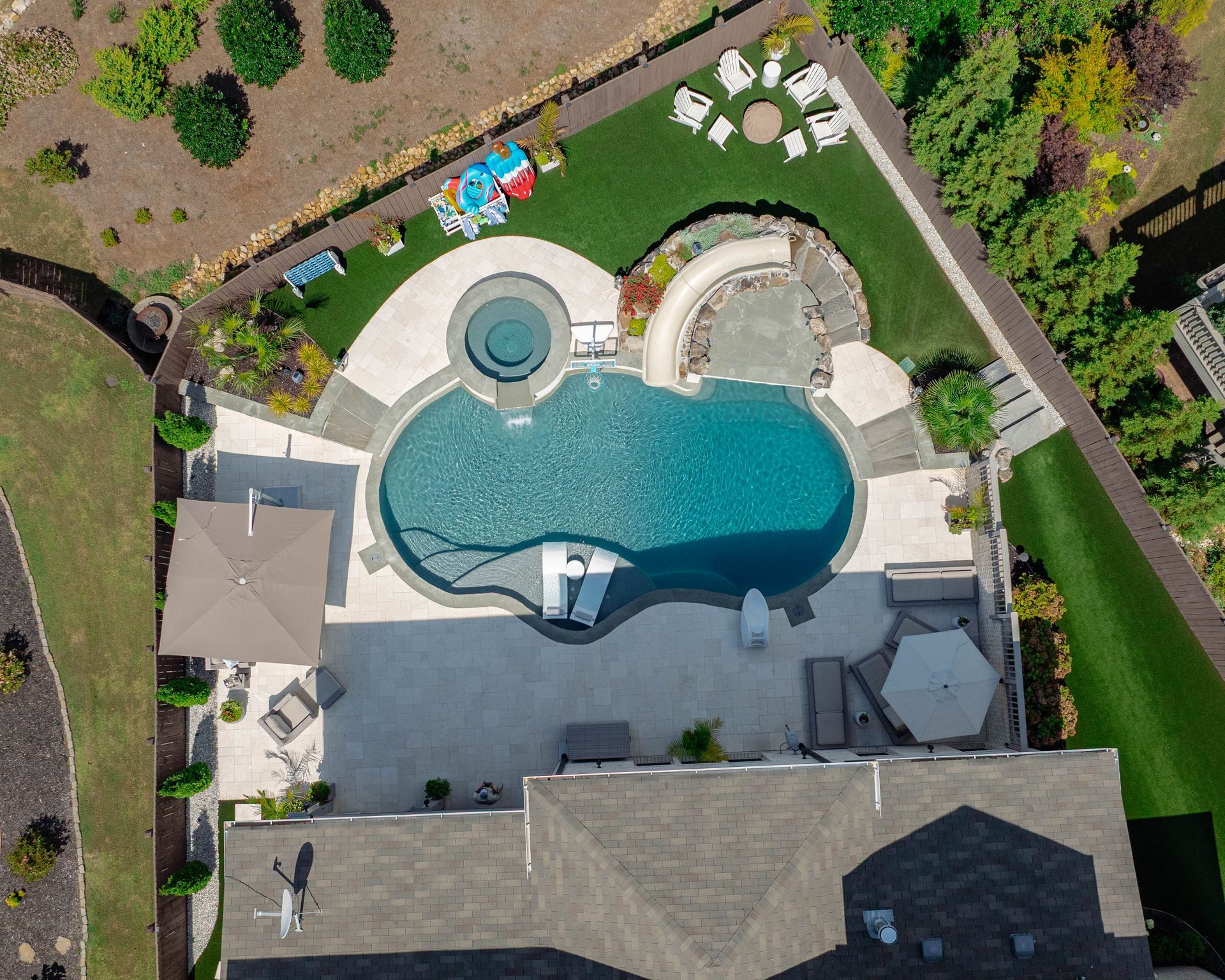 a filled pool in the backyard with nice flowers and landscaping