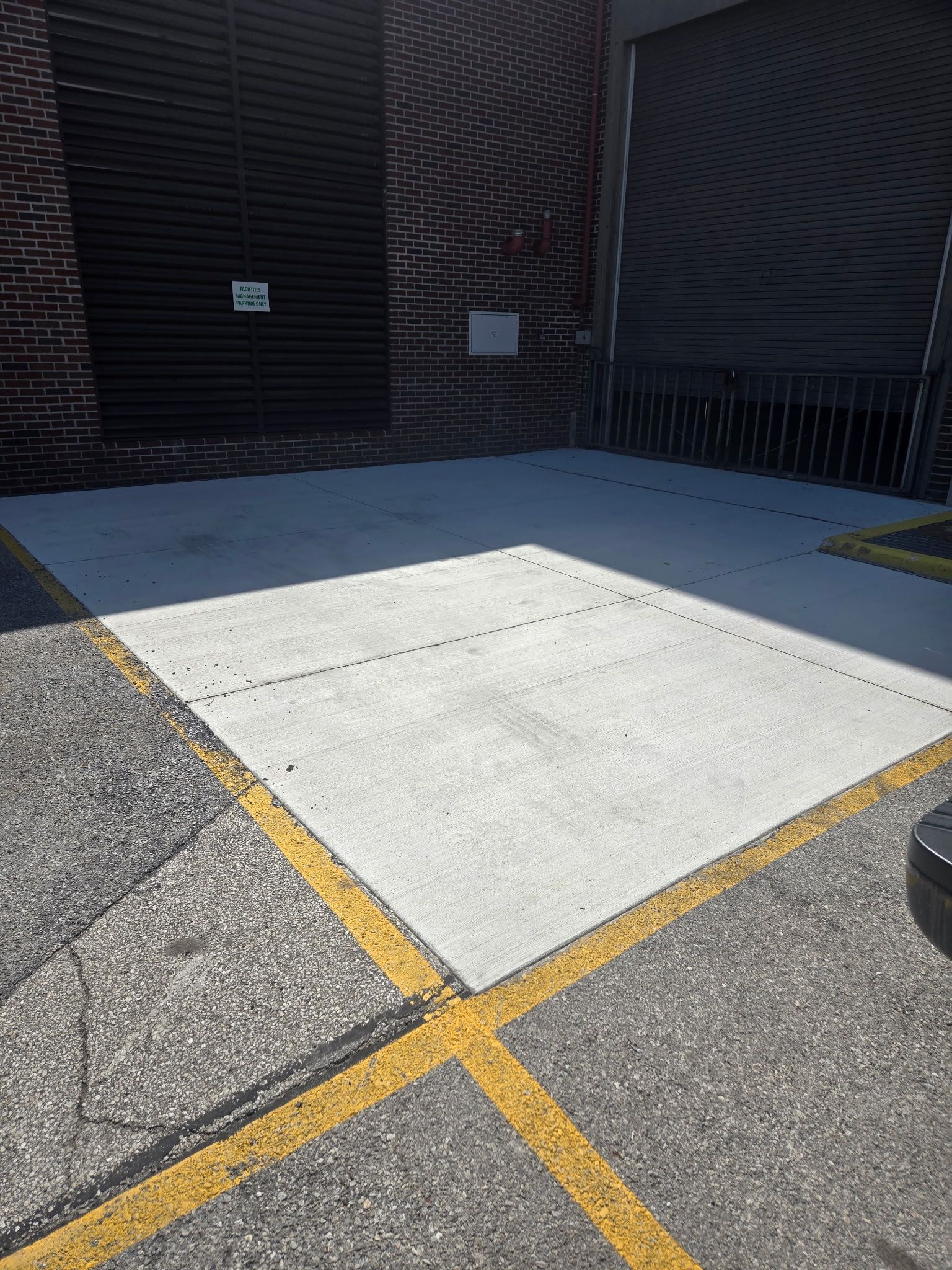 A car is parked in a parking lot next to a brick building.