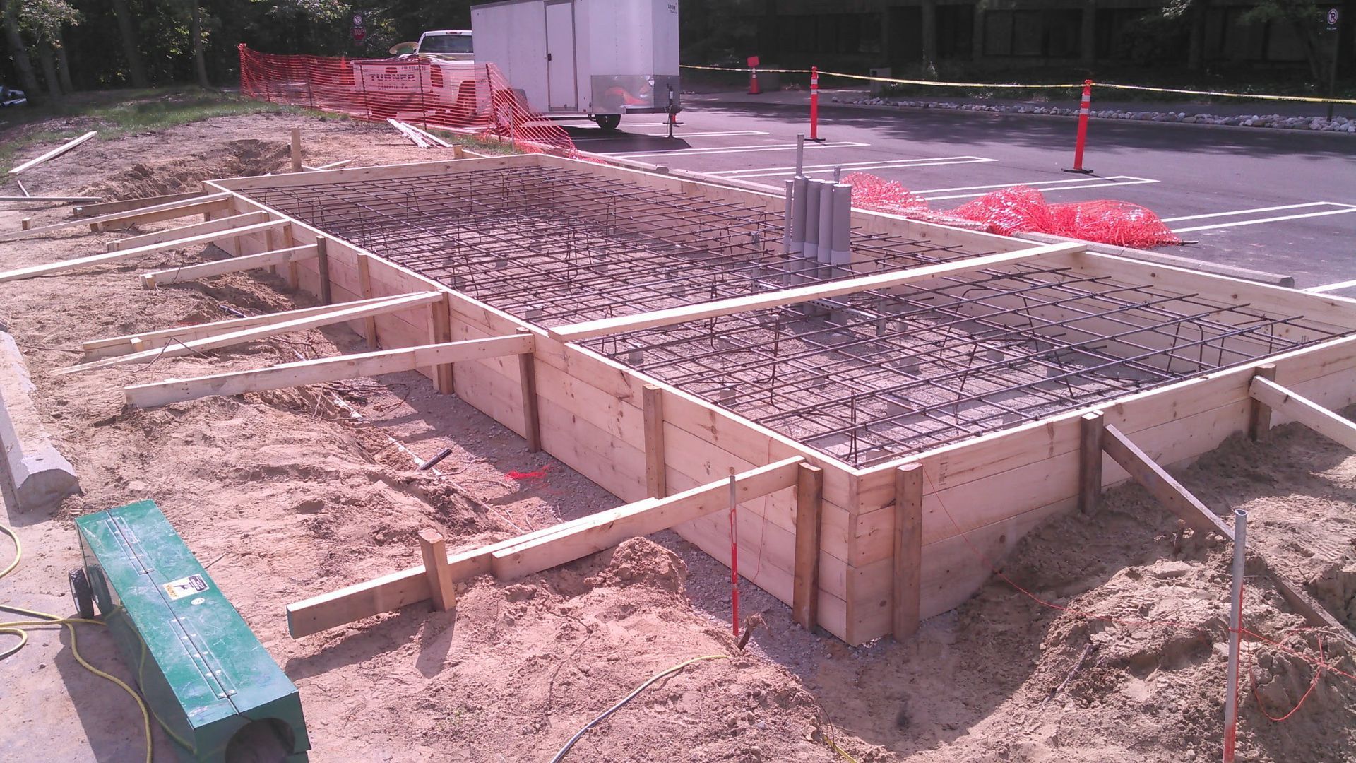 A green bench sits in the middle of a construction site
