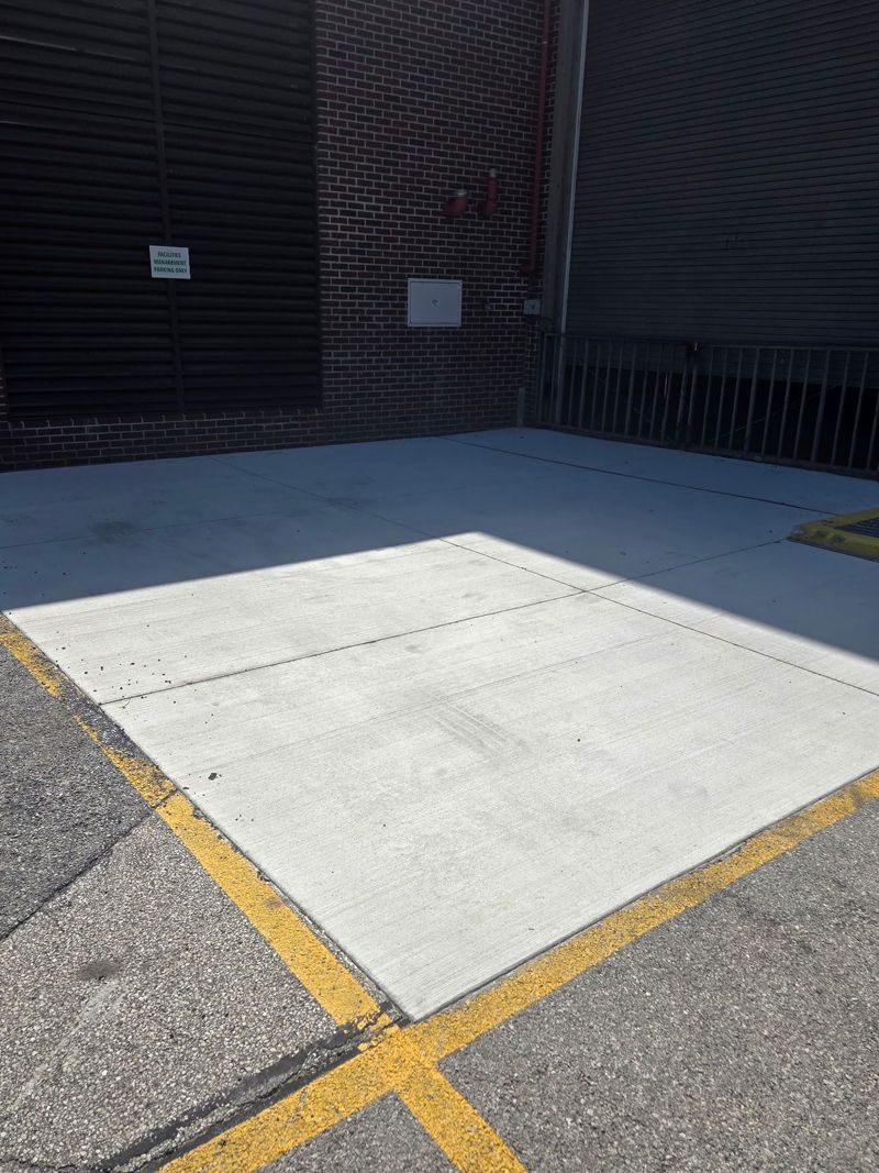 A concrete surface with a yellow line on it in front of a building.
