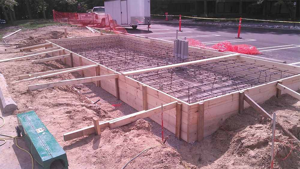 A concrete foundation is being built on the side of the road