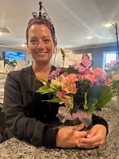 A woman wearing a headband is holding a bouquet of flowers.