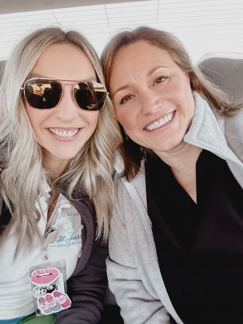 Two women wearing sunglasses are posing for a picture together.