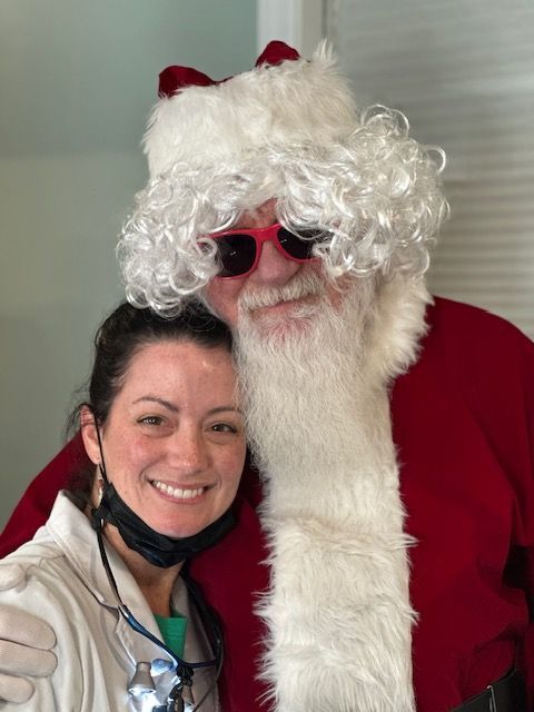 A woman and Santa Claus smiling together.