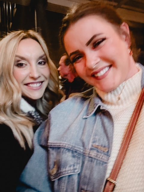 Two smiling women pose for a selfie.
