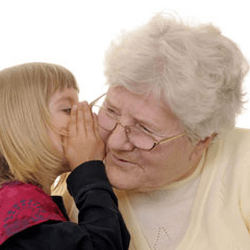 a little girl is whispering something into an older woman's ear