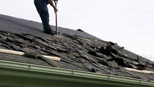 Removing old shingles to prepare a roof for a new installation