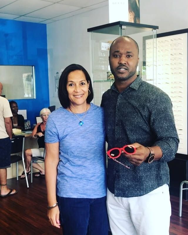 A man and a woman are posing for a picture in an optical store