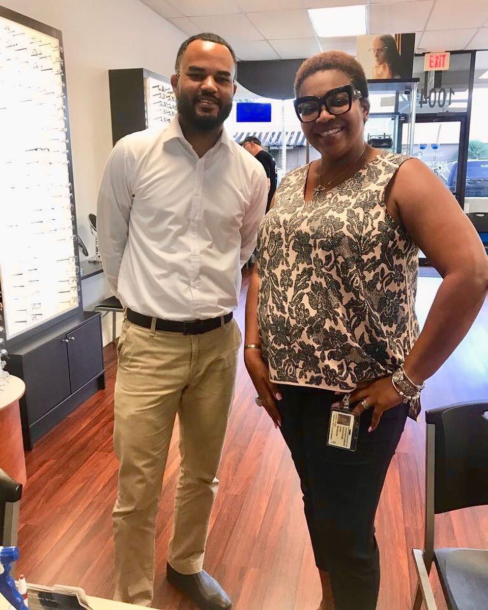 A man and a woman are posing for a picture in an optical shop