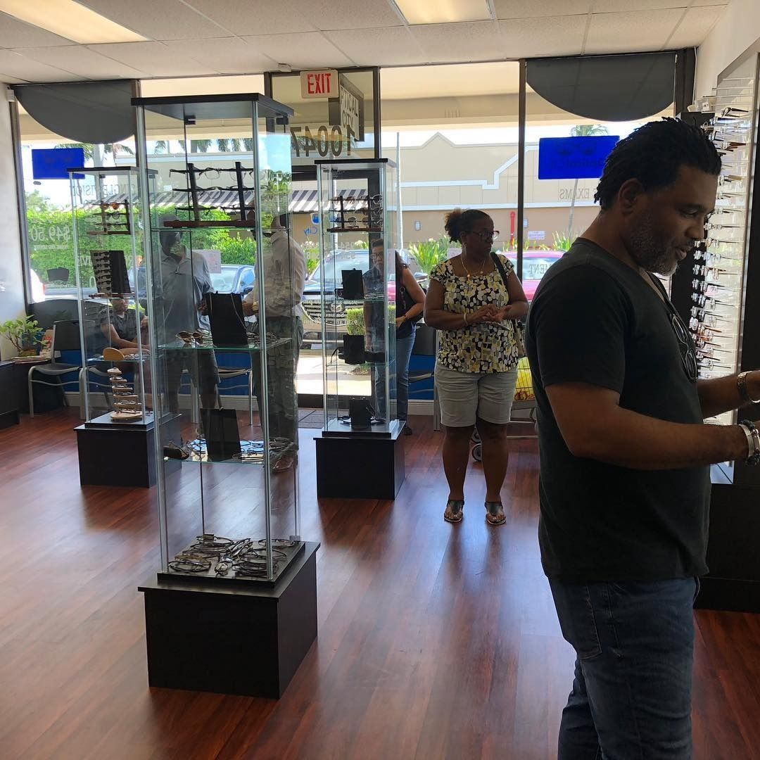A man in a black shirt is looking at his phone in a store