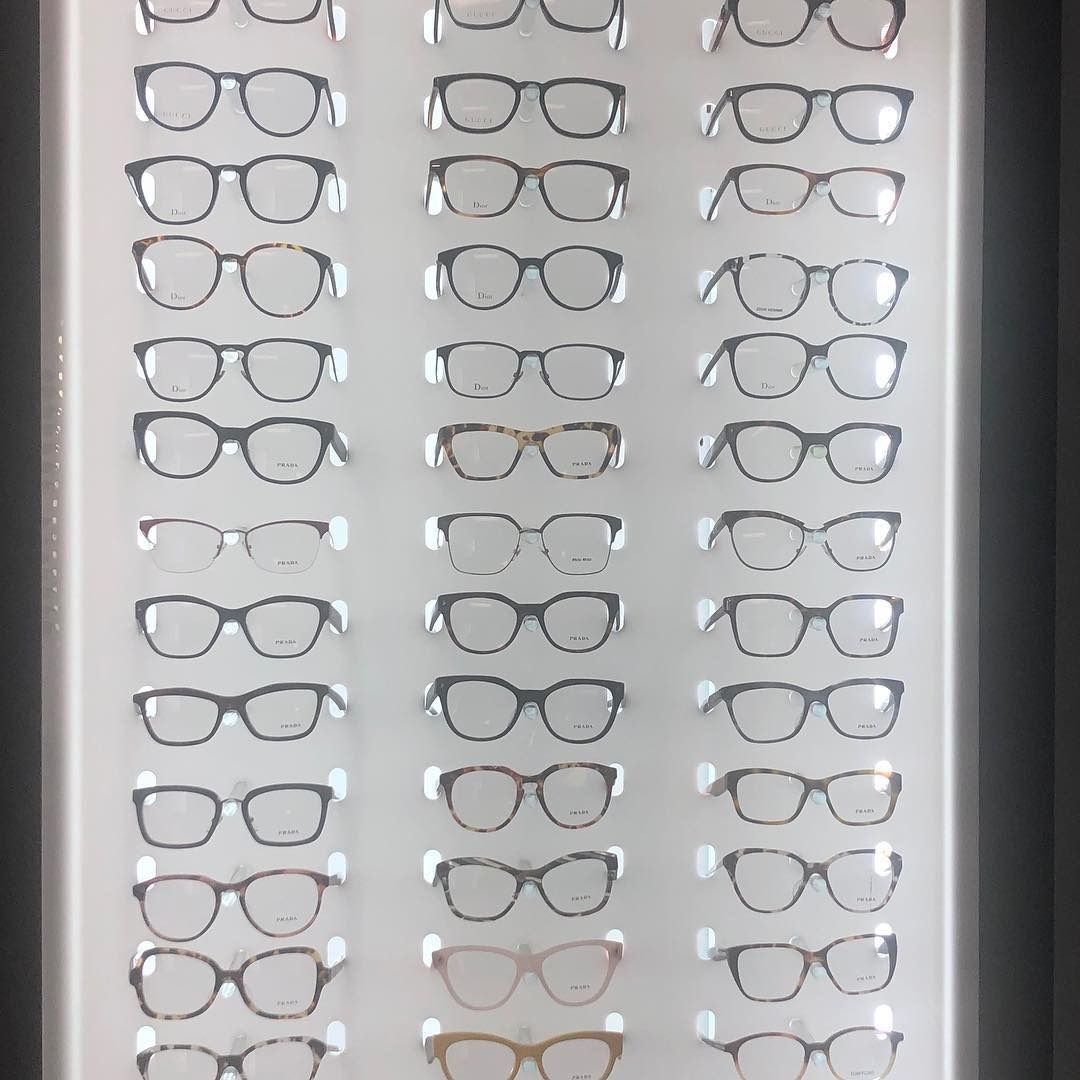 A row of glasses hanging on a wall in a store