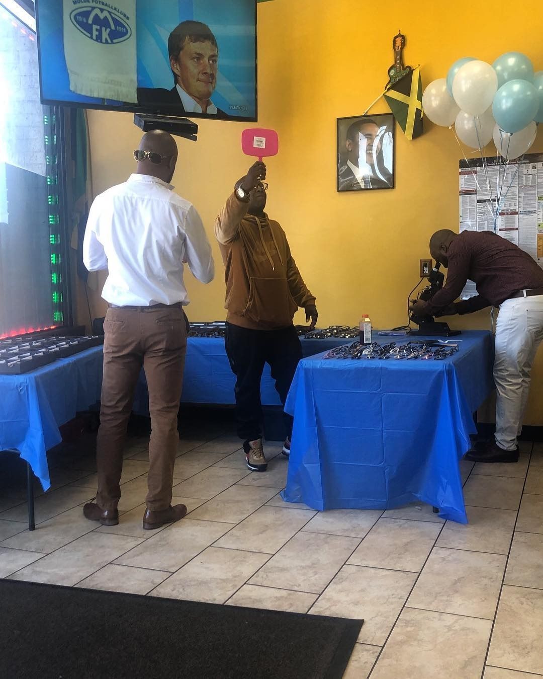 A group of people standing around tables in a room