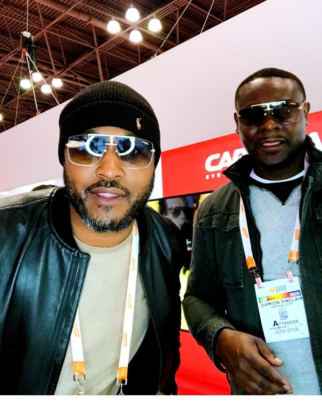 Two men are posing for a picture in front of a sign that says caf