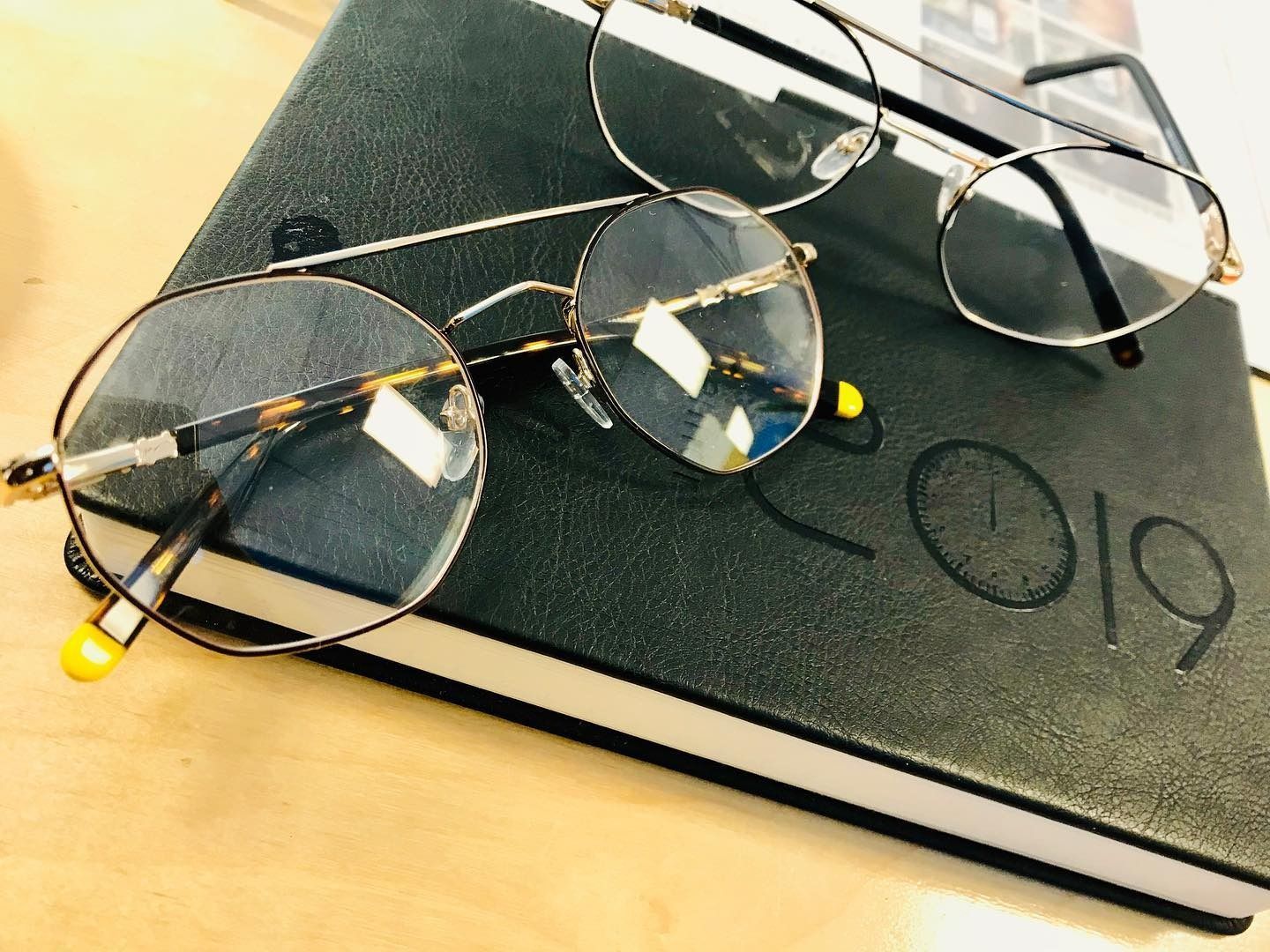 A pair of glasses laying on top of a notebook that says 2019