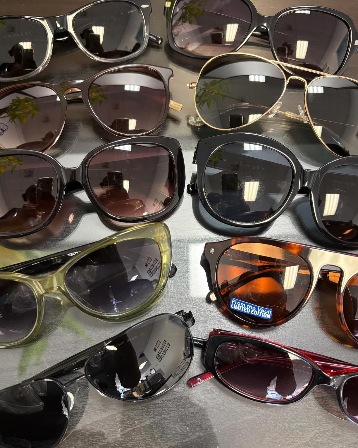A bunch of sunglasses are lined up on a table