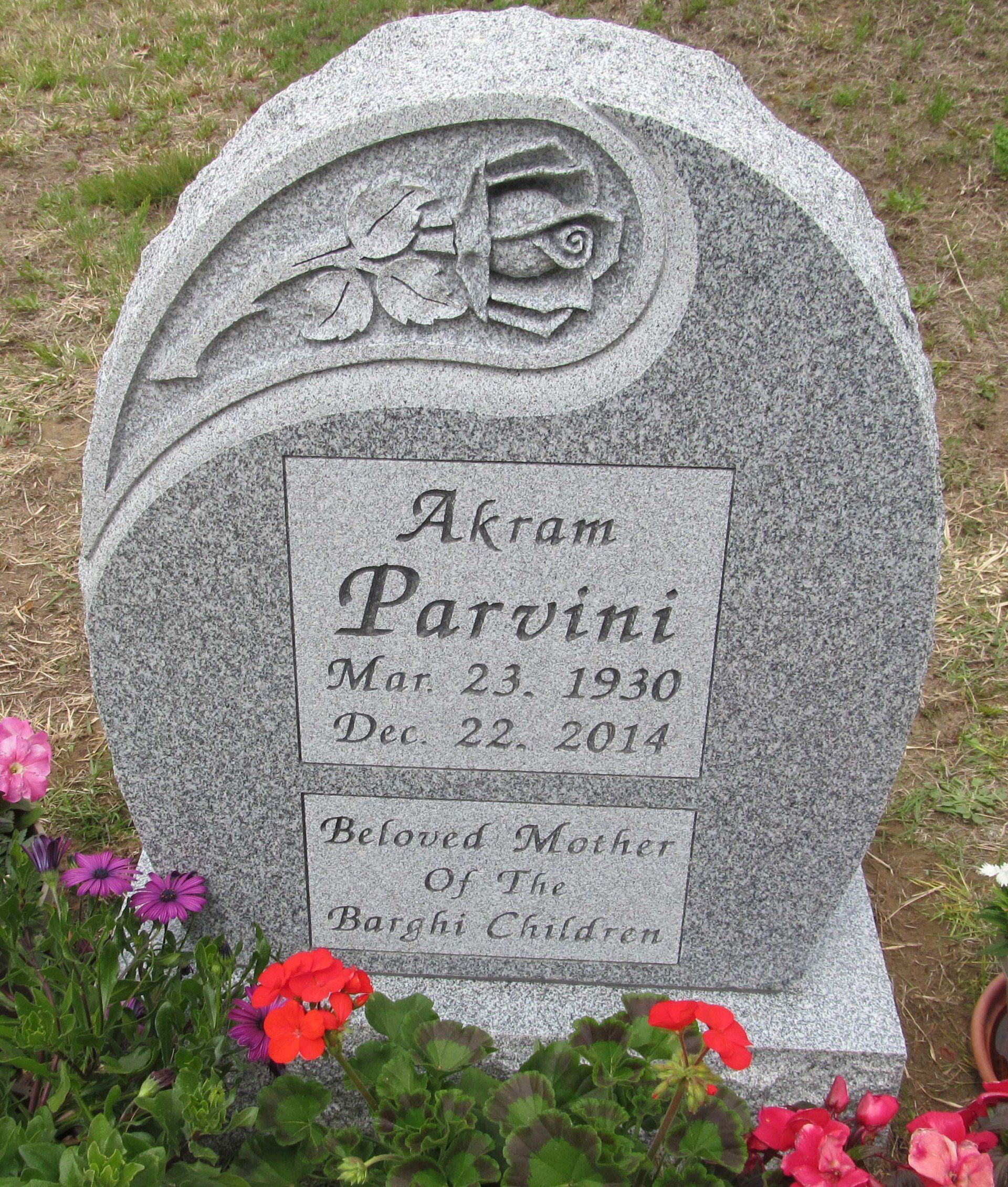 A gravestone for a child named akram parvini is surrounded by flowers.