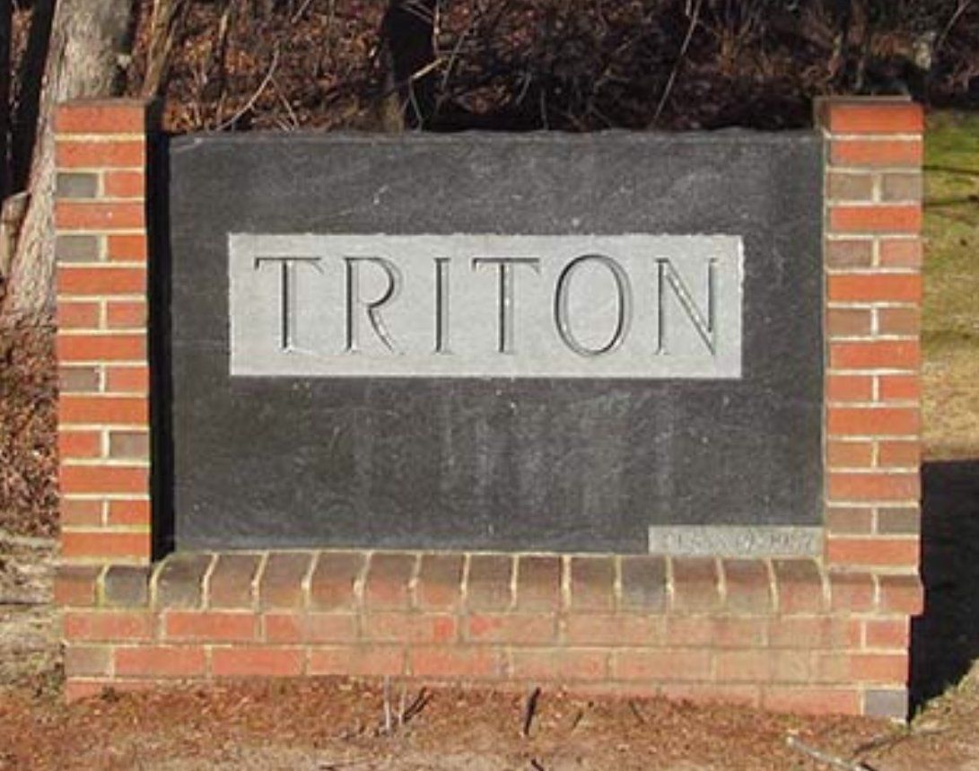 A brick wall with a sign that says triton on it