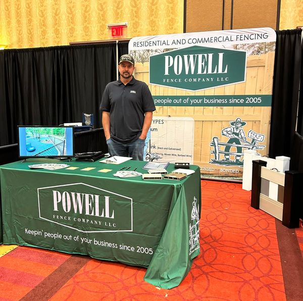 Man stands behind a trade show booth promoting 