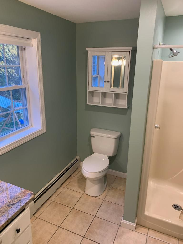 A bathroom with a toilet , sink , and shower.