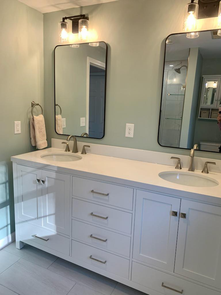 A bathroom with two sinks and two mirrors.