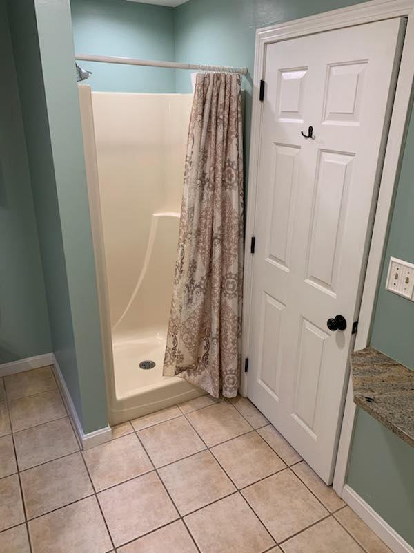 A bathroom with a shower and a door.