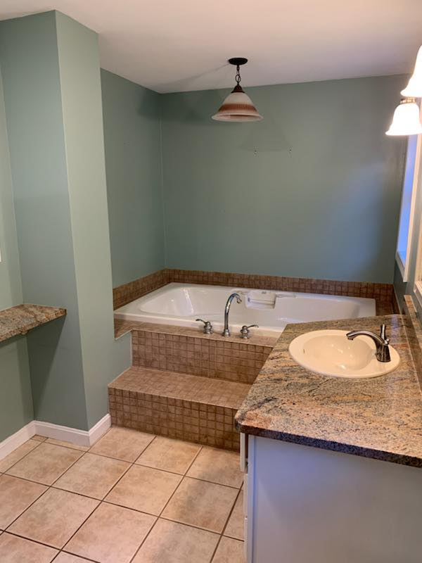 A bathroom with a jacuzzi tub and a sink.