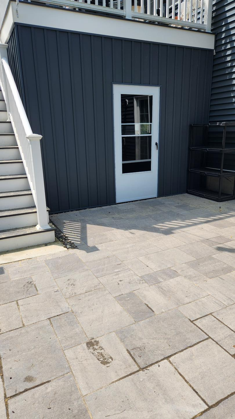 A black house with a white door and stairs.